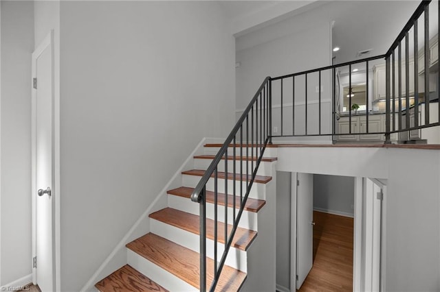 stairway featuring baseboards and wood finished floors