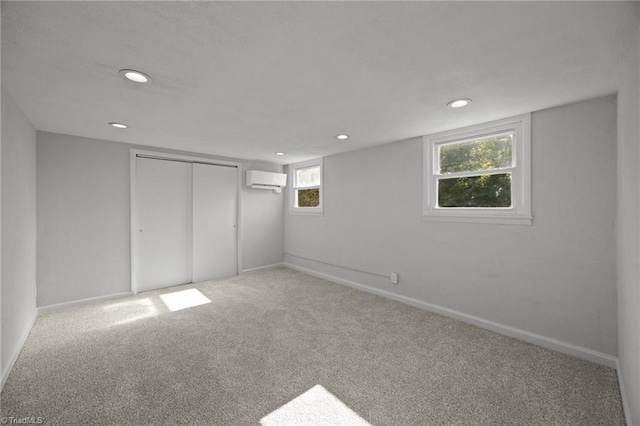 basement featuring baseboards, carpet flooring, a wall mounted air conditioner, and recessed lighting