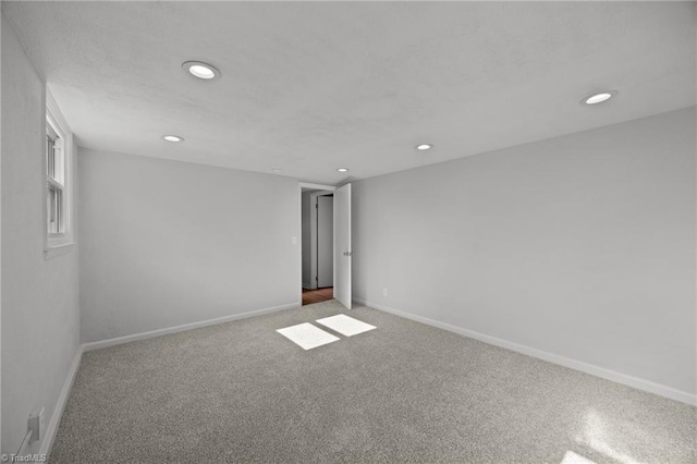 carpeted empty room with baseboards and recessed lighting