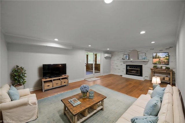 living room featuring recessed lighting, wood finished floors, baseboards, and an AC wall unit