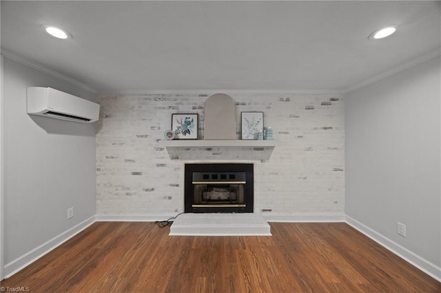unfurnished living room with a wall mounted air conditioner, baseboards, crown molding, wood finished floors, and a large fireplace