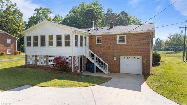 back of property with an attached garage, brick siding, a yard, concrete driveway, and a chimney