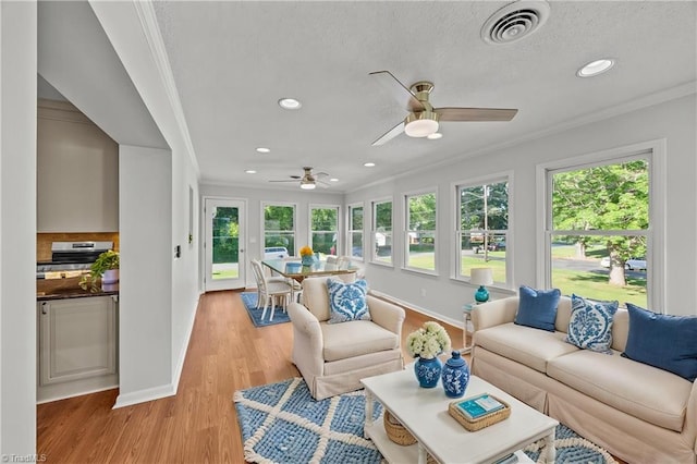 sunroom / solarium with ornamental molding, plenty of natural light, and visible vents