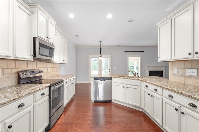 2403 Hammock Dr, High Point, NC 27265 - kitchen featuring stainless steel appliances, dark wood-style floors, a peninsula, white cabinetry, and decorative backsplash