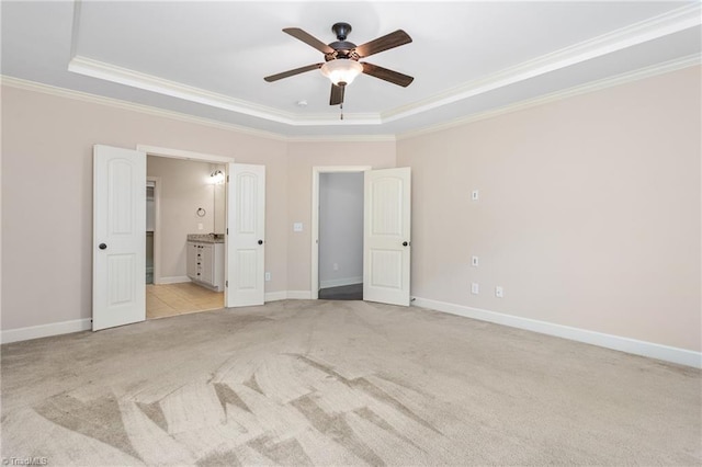 2403 Hammock Dr, High Point, NC 27265 - unfurnished bedroom with light carpet, a tray ceiling, ornamental molding, connected bathroom, and ceiling fan