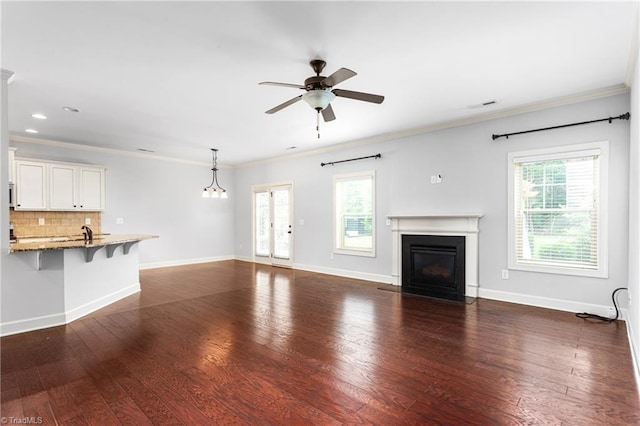 2403 Hammock Dr, High Point, NC 27265 - unfurnished living room featuring a ceiling fan, healthy amount of natural light, a fireplace with flush hearth, dark wood finished floors, and ornamental molding