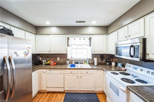 kitchen with white cabinetry, stainless steel appliances, light hardwood / wood-style floors, and sink