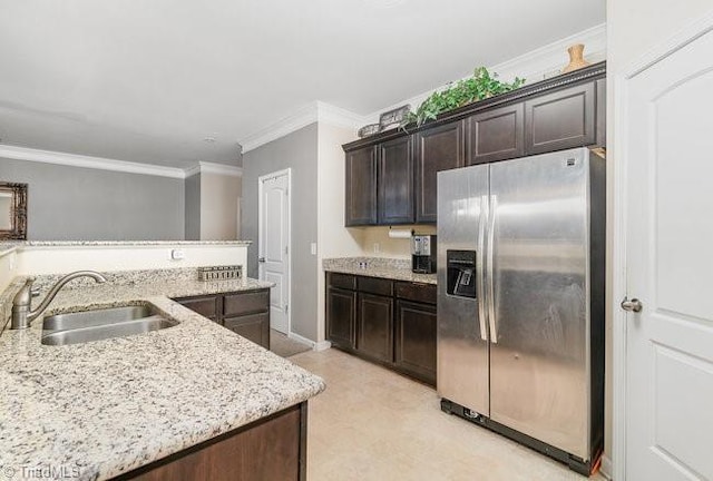 kitchen with sink, stainless steel fridge, ornamental molding, light stone counters, and dark brown cabinets