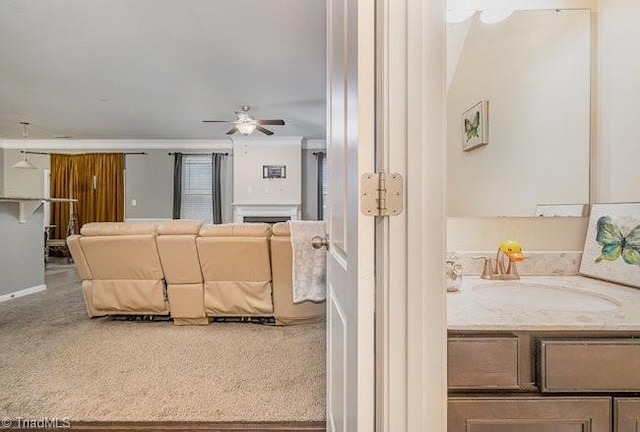 carpeted living room with ceiling fan and sink