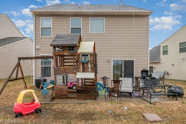 rear view of house featuring central AC unit, a playground, and a patio