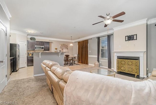 carpeted living room with ornamental molding and ceiling fan