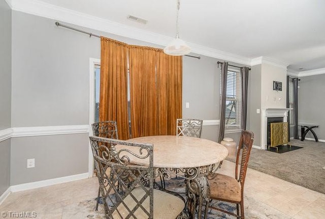 carpeted dining space with ornamental molding