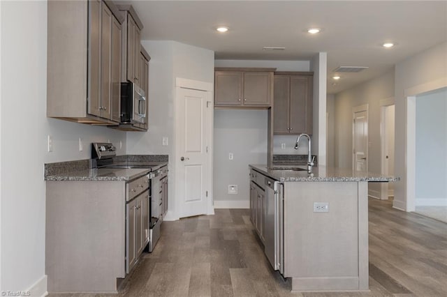 206 Cason Dr, Gibsonville, NC 27249 - kitchen featuring appliances with stainless steel finishes, a sink, wood finished floors, stone counters, and recessed lighting