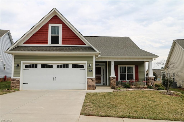 craftsman inspired home featuring a porch, a shingled roof, concrete driveway, stone siding, and a front lawn