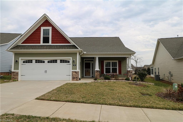 craftsman inspired home featuring a shingled roof, covered porch, central AC unit, a front yard, and driveway