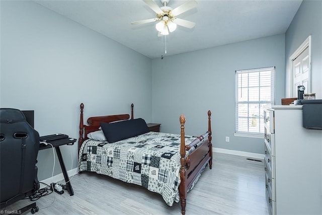 bedroom with light wood-type flooring, ceiling fan, and baseboards