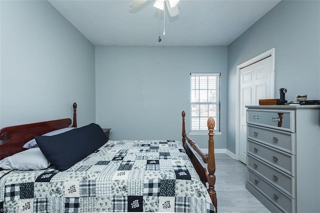 bedroom featuring light wood-style floors, a closet, baseboards, and a ceiling fan