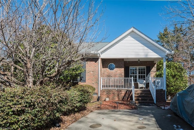 view of front of house with covered porch and brick siding