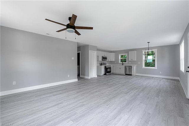 300 Center St, Thomasville, NC 27360 - unfurnished living room with a ceiling fan, light wood finished floors, baseboards, and a chandelier
