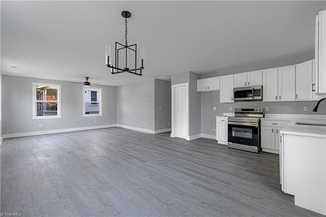 300 Center St, Thomasville, NC 27360 - kitchen featuring stainless steel appliances, a ceiling fan, a chandelier, a sink, and light countertops