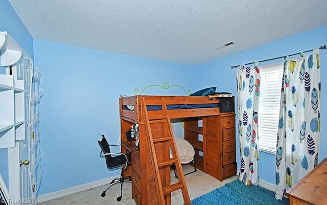 bedroom featuring light carpet and a textured ceiling