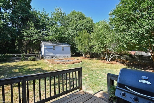 wooden terrace with a storage unit and a lawn