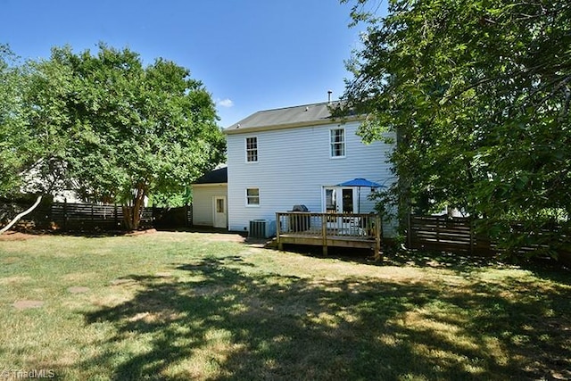 rear view of property with a wooden deck, a yard, and central air condition unit