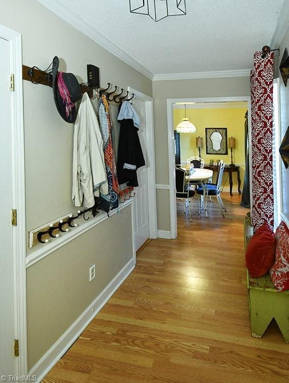 5467 Moravian Heights Ln, Clemmons, NC 27012 - mudroom featuring light wood-style flooring, a textured ceiling, and crown molding