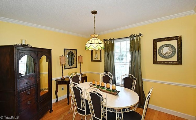 dining room featuring crown molding, hardwood / wood-style flooring, and a textured ceiling