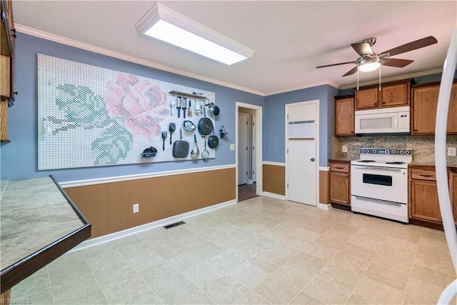 1625 Eagle Crest Dr, Pfafftown, NC 27040 - kitchen with white appliances, brown cabinets, crown molding, ceiling fan, and a textured ceiling