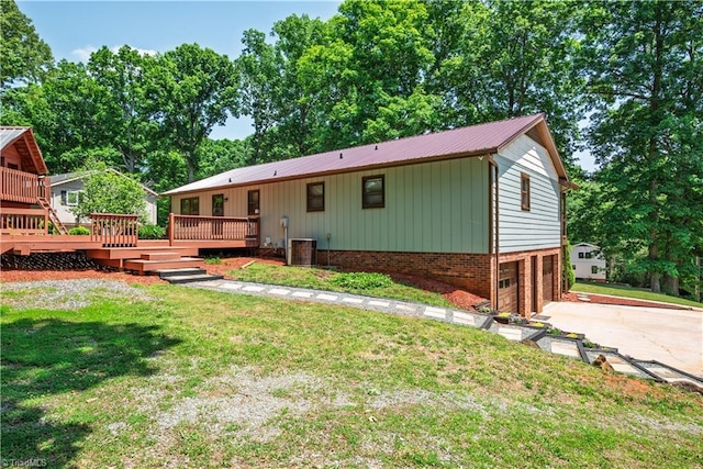 1625 Eagle Crest Dr, Pfafftown, NC 27040 - back of house with a deck, an attached garage, driveway, metal roof, and a lawn