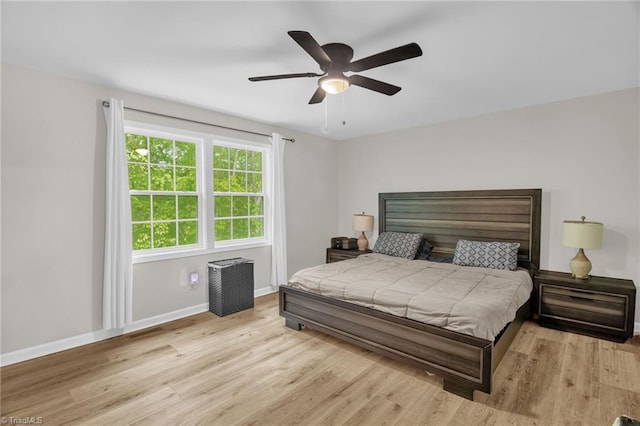 bedroom featuring baseboards, ceiling fan, and light wood-type flooring