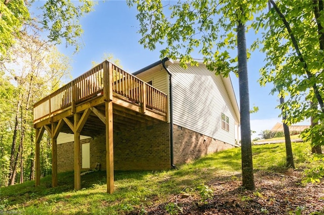 exterior space featuring a wooden deck and brick siding