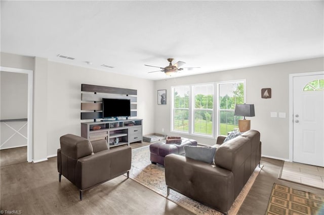 living room featuring ceiling fan, visible vents, and wood finished floors