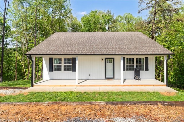 view of front of property featuring covered porch and a shingled roof