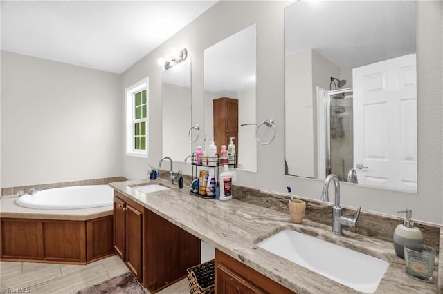 full bath featuring a sink, a garden tub, a stall shower, and double vanity