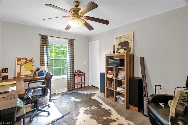 home office with baseboards, a ceiling fan, wood finished floors, and visible vents