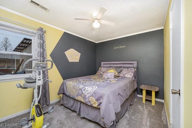 carpeted bedroom featuring ceiling fan, ornamental molding, and a textured ceiling