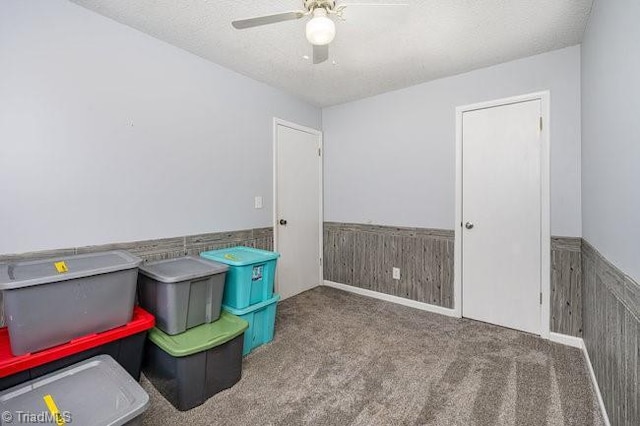 recreation room with ceiling fan, light colored carpet, and a textured ceiling