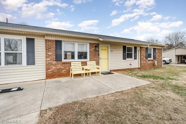 ranch-style home with a patio and a front lawn