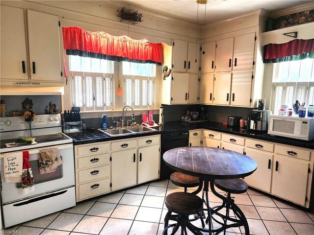 kitchen featuring white appliances, a sink, under cabinet range hood, light tile patterned floors, and crown molding