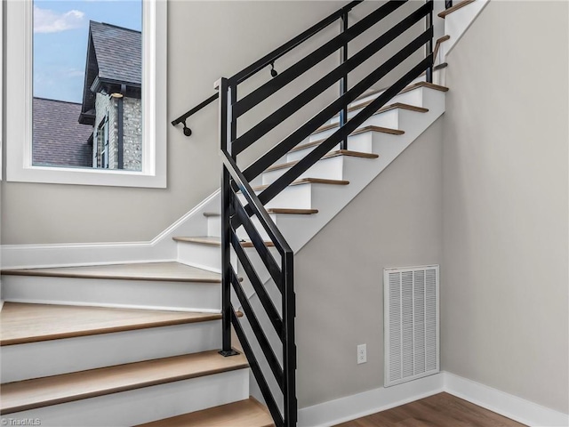 staircase with hardwood / wood-style flooring