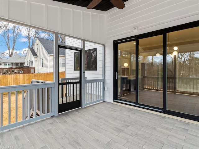 unfurnished sunroom with ceiling fan