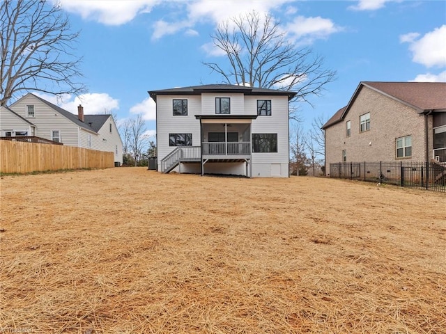 rear view of house with a sunroom and a yard