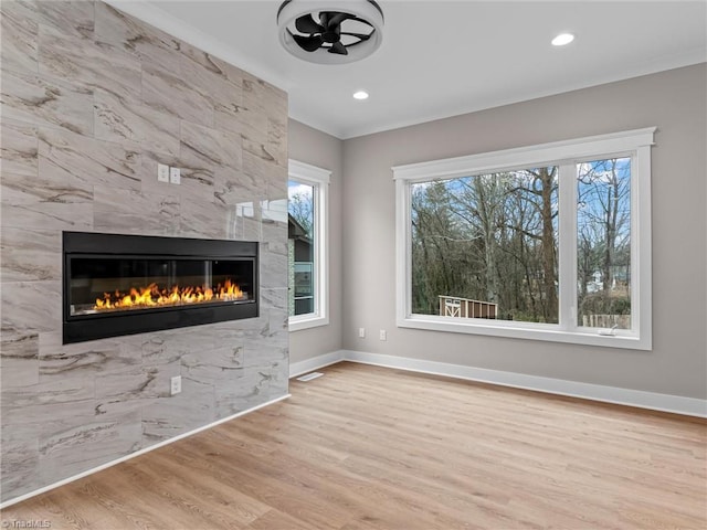 unfurnished living room featuring a tile fireplace and light wood-type flooring