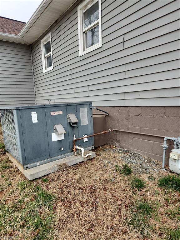 details with gutters, central AC, and gas meter