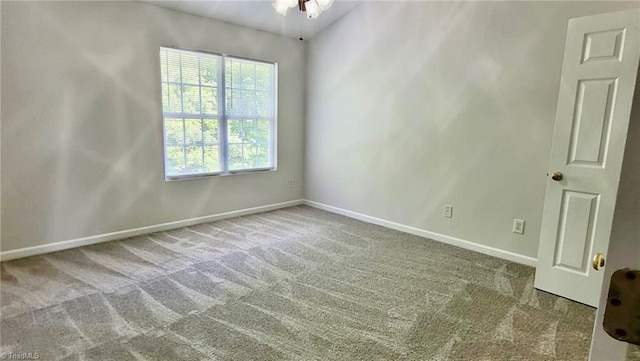 carpeted empty room featuring ceiling fan and baseboards