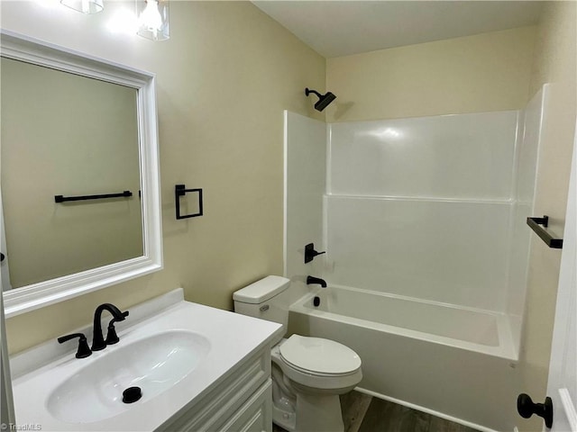 full bathroom with hardwood / wood-style floors, vanity, bathtub / shower combination, and toilet