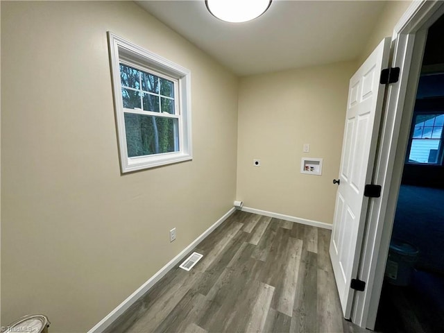 washroom with electric dryer hookup, washer hookup, a healthy amount of sunlight, and hardwood / wood-style flooring