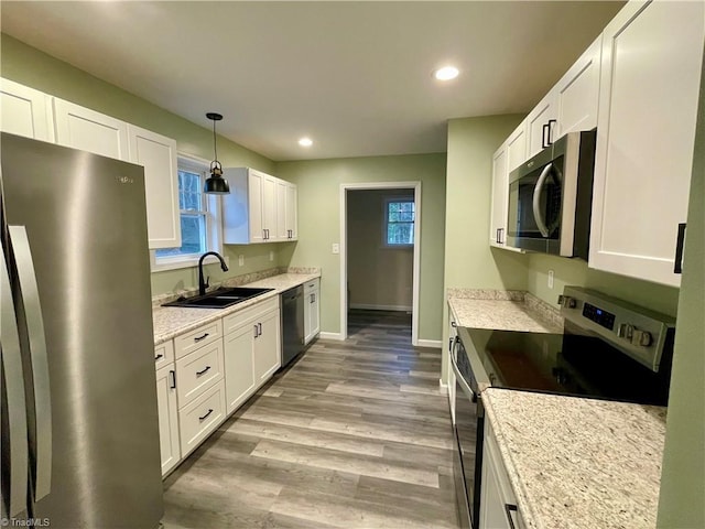 319 E 3rd Ave Extension, Lexington, NC 27292 - kitchen featuring stainless steel appliances, white cabinetry, recessed lighting, plenty of natural light, and light wood-type flooring